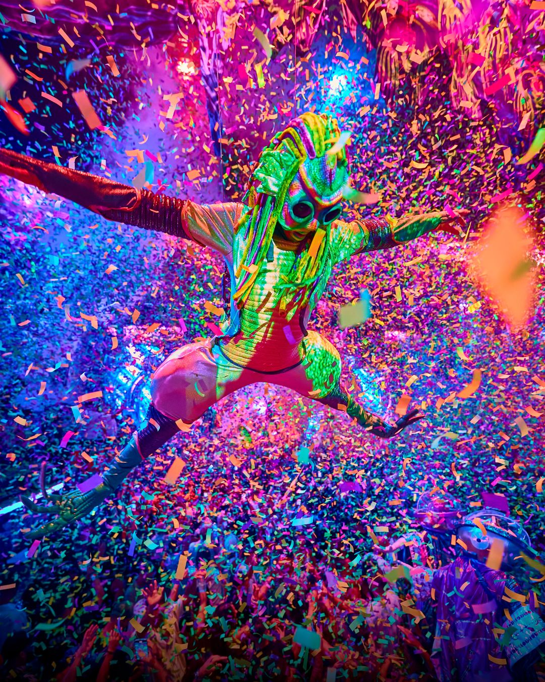 Performer acróbata de elrow Tenerife suspendida entre confeti