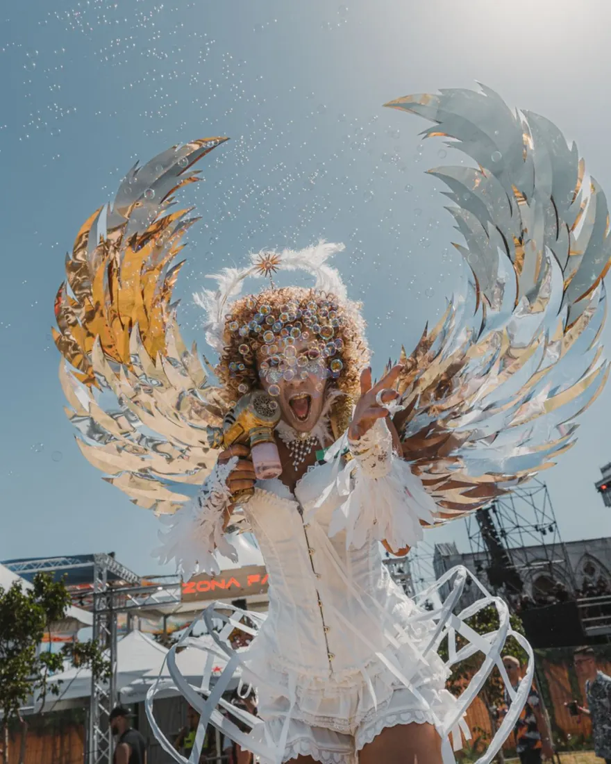 Artista con alas plateadas en La Misa